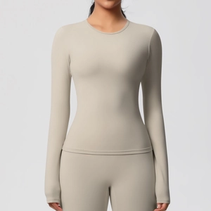 Vue détaillée du haut de yoga beige à manches longues en tissu élastique et col rond