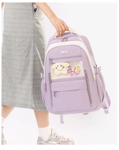 Detail view of the purple nylon school bag with a transparent front pocket and cute charms