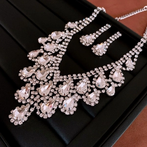 Detailed close-up of a silver rhinestone water drop necklace and earring jewelry set