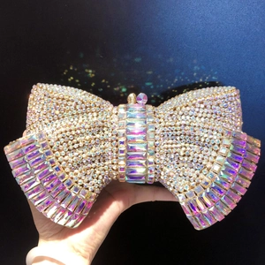 Detail of golden bow clutch bag featuring sparkling white rhinestones and iridescent gems