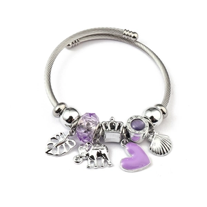 Detailed macro view of purple faceted beads, heart charm and crown pendant on woven bracelet