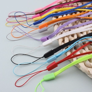 Close-up of colorful nylon braided lanyards with plastic buckles on a rustic mat