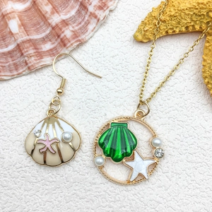 Detail shot of ocean-themed jewelry set with seashell charms and faux pearls