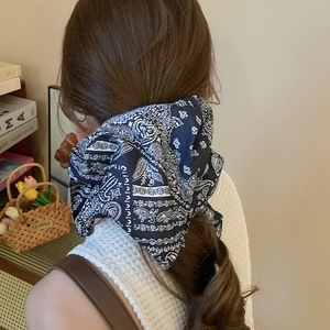 Serre-tête en tissu imprimé cachemire bleu marine porté par une femme dans un décor cosy