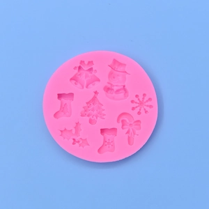 Pink round Christmas silicone mold with snowman, tree, and bell shapes for DIY baking