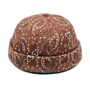 Detailed close-up of brown paisley print corduroy docker cap with vintage texture