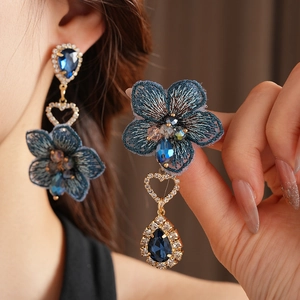 Vue détaillée des boucles d'oreilles asymétriques vintage fleur bleue avec gouttes en cristal