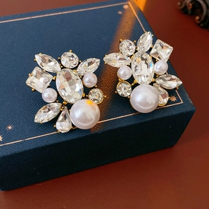Macro shot of vintage gold earrings with clear crystals and elegant teardrop pearls