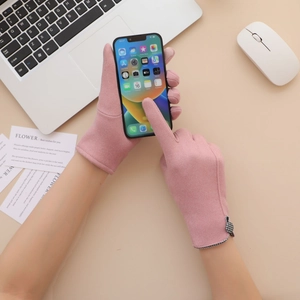 Pink thermal gloves featuring touchscreen-compatible fingertips used on a smartphone