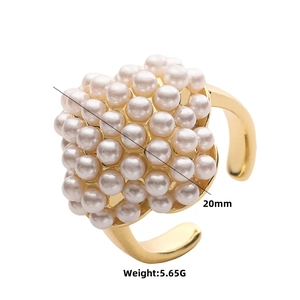 Detailed view of adjustable gold-plated ring with clustered white pearls and star accents