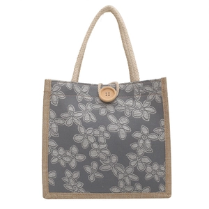 Gray floral canvas tote bag with rustic rope handles and wooden button closure