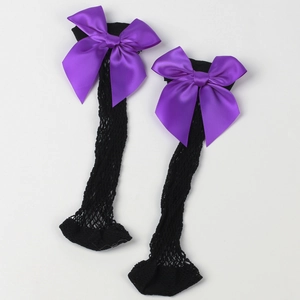 Detail view of black mesh socks featuring a large purple satin bow on white background