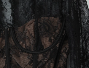 Detailed macro view of black floral lace and corset boning structure over beige lining