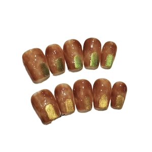 Maillard amber brown press-on nails with green and gold glitter in a square oval shape