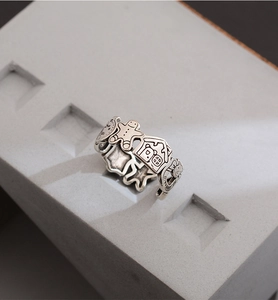 Detail of vintage silver gingerbread man ring with cartoon engravings on stone surface