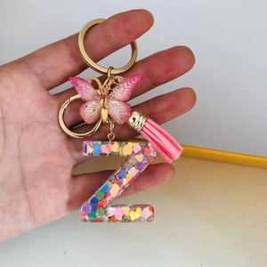 Detail of resin letter Z keychain with pink butterfly, tassel and colorful heart sequins