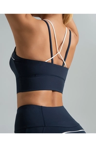 Détail d'un soutien-gorge de yoga dos croisé bleu foncé et blanc à maintien élevé