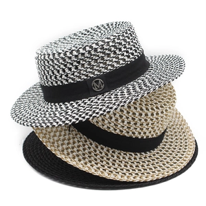 Three-piece stack of straw sun hats with black ribbon bands and metal logo details