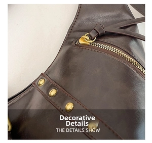 Close-up of vintage dark brown leather bag with gold metal zipper and round stud details