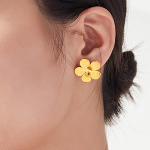 Golden five-petal flower stud earring in stainless steel on a model's ear