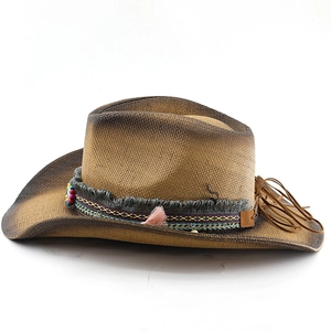 Dettaglio cappello cowboy in paglia marrone sfumata con ricamo etnico e piuma rosa