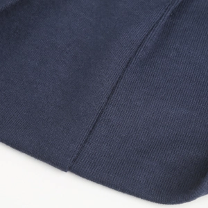 Detailed close-up of navy blue knitted fabric texture and fine stitching on the hat