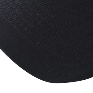 Detailed close-up of black cotton twill baseball cap fabric with reinforced stitching