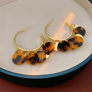 Details von goldenen Creolen mit Acryl-Anhängern in Schildpatt-Leoparden-Optik