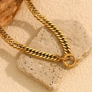 Detail of 18K gold plated thick chain necklace with round spring clasp on stone