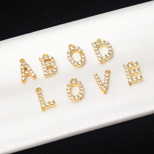 Detailed view of gold-plated micro-pave letter charms for personalized jewelry making