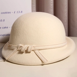 Detail of beige wool felt cloche hat with rolled brim and delicate gold buckle belt