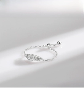Macro detail of S925 sterling silver feather ring with sparkling zircon inlays on soft chain