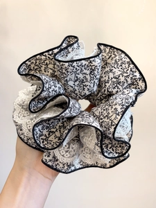 Détail d'un chouchou à fleurs avec bordure en dentelle et style rétro français