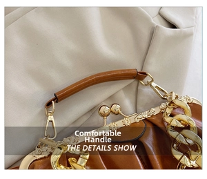 Detail of caramel brown pleated leather handbag with vintage gold metal frame and ball clasp
