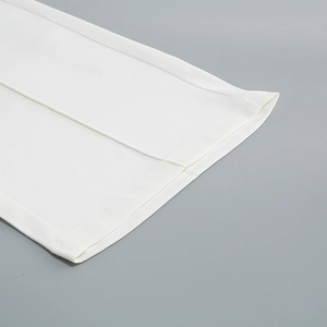Close-up of the hem stitching and woven fabric texture on white formal trousers