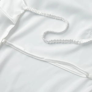 Gros plan d'un haut licou en satin blanc avec bretelles réglables et détails élastiques