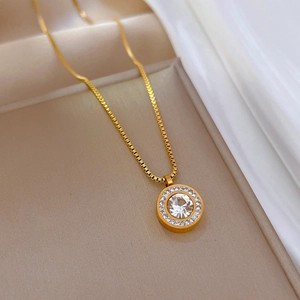 Détail du collier en acier titane doré avec pendentif cercle serti de cristaux