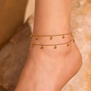 Double-layered golden stainless steel anklet with round beads on model ankle