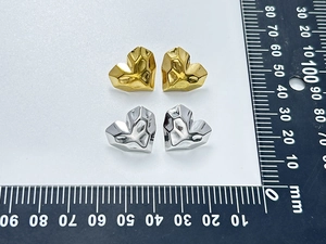 Detailed macro view of 15mm quilted heart stud earrings in gold and silver finish
