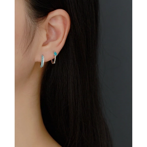 Close-up of S925 sterling silver twist drop earrings with blue gemstones on a model