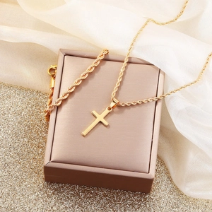 Exquisite gold cross necklace set displayed on a premium gift box with silk accents