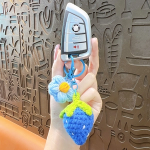 Handmade crochet strawberry and flower keychain accessory on a car key handle