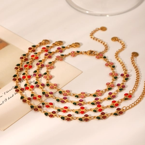 Detailed shot of cherry charms in red and pink enamel on 18K gold plated chains