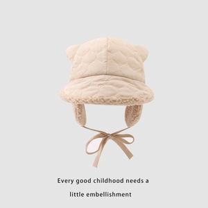 Detail of winter trapper hat for kids featuring quilted fabric and plush bear ears