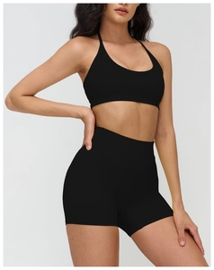 Détail de la brassière de sport noire dos nu et du short taille haute en maille côtelée