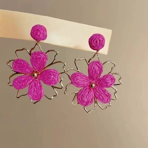 Elegant handmade magenta raffia flower drop earrings with a gold-toned metal petal outline