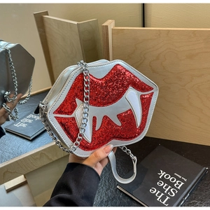 Détail du sac bandoulière argenté avec lèvres de vampire en paillettes rouges et crocs