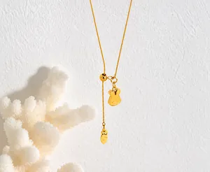 Close-up of golden necklace featuring a cute rabbit head pendant and a carrot charm
