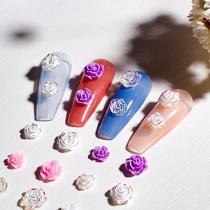 Macro shot of 3D resin rose nail charms with pearl and aurora finish on acrylic nails