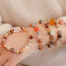 Macro detail of natural stone beaded bracelets with cute animal charms on female wrist